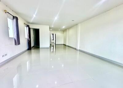 Spacious unfurnished main living area with glossy tile floors and bright lighting