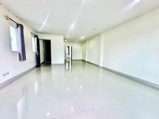 Spacious unfurnished main living area with glossy tile floors and bright lighting