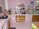 Spacious kitchen with pink tiled walls, countertops, and ample storage