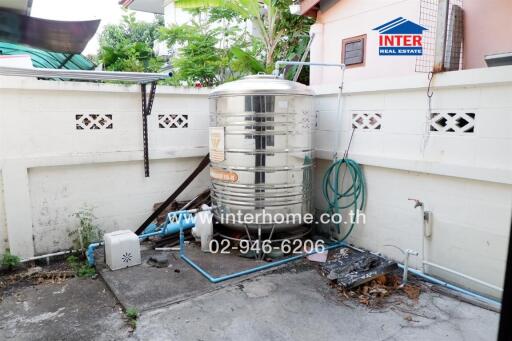 Outdoor utility area with a large water tank