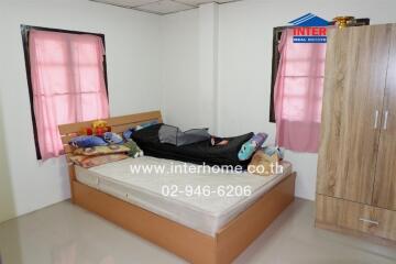 Bright bedroom with pink curtains and wooden furniture