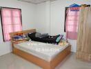 Bright bedroom with pink curtains and wooden furniture