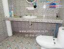 Bathroom with tiled walls and floors, a countertop sink, and a toilet