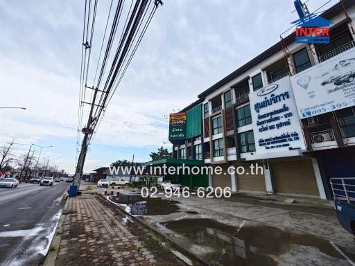 Street view of a commercial building with advertisements