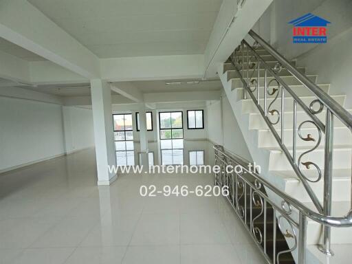 Spacious main living area with staircase and large windows