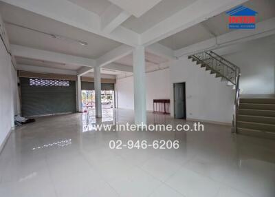 Spacious commercial property with a large open area, stairs, and roll-up doors