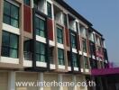 Four-story commercial building with various windows and balconies