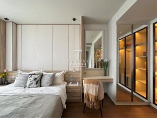 Cozy and modern bedroom with wooden accents, double bed, vanity desk, and walk-in closet