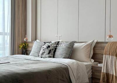 A cozy bedroom with a modern design, featuring a comfortable bed with soft pillows, contemporary lighting, and stylish decor.