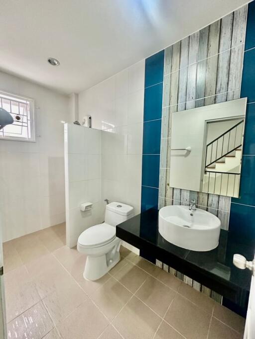 Modern bathroom with blue accent wall and white fixtures