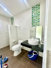 Modern bathroom with sink, toilet, and tiled walls