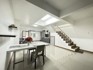 Main living space with dining area, skylight, staircase, and open layout