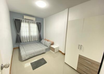 Modern well-lit bedroom with bed and wardrobe
