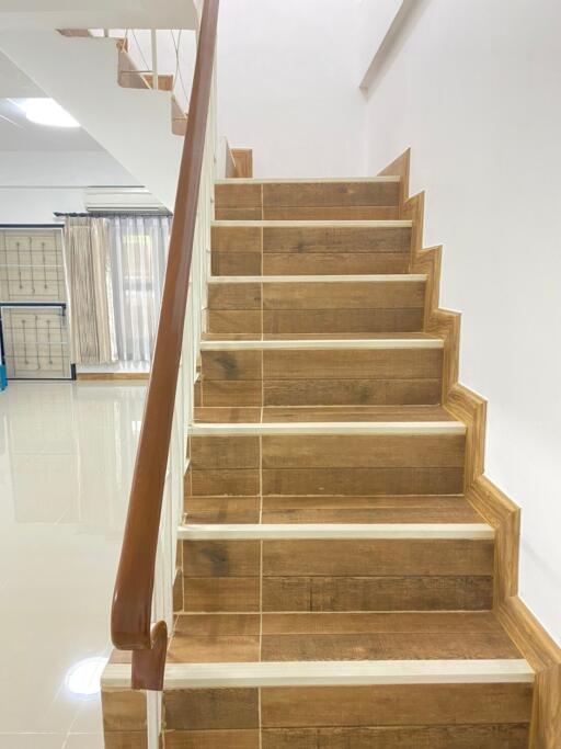 Wooden staircase leading to the upper floor with polished handrail