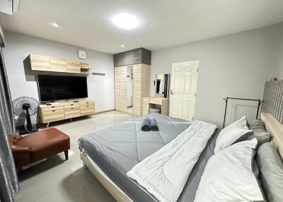 Modern bedroom with king-sized bed, wall-mounted TV, and wardrobe