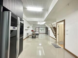 Modern kitchen and dining area with staircase and large fridge