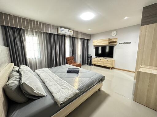 Spacious bedroom with modern furniture and a large window