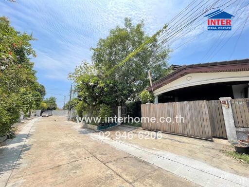 Street view of residential property with house and wooden gate