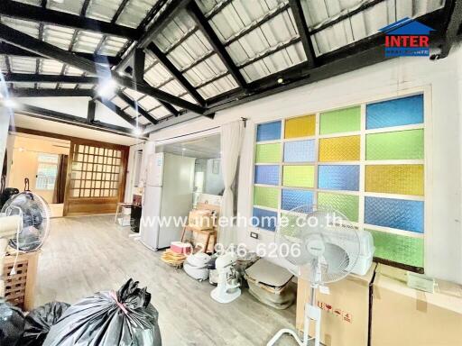 interior of a building with colorful glass pane wall, fans, and various items