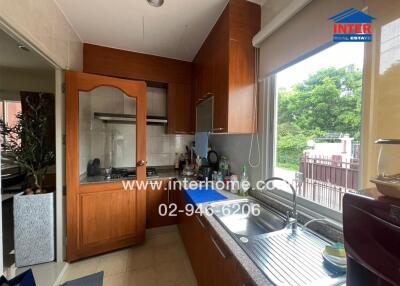 Modern kitchen with wooden cabinets, gas stove, and large window
