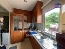 Modern kitchen with wooden cabinets, gas stove, and large window