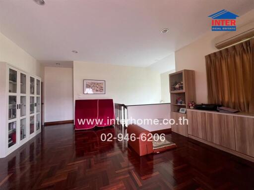 Spacious living room with wooden flooring and built-in furniture