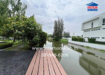 View of modern property with canal and lush greenery
