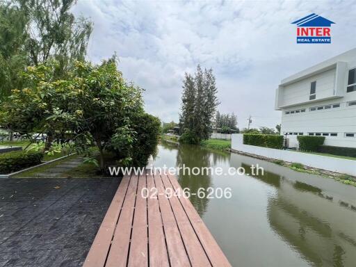 View of modern property with canal and lush greenery