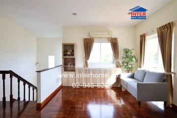 Spacious living room with hardwood floors, large windows and a grey couch