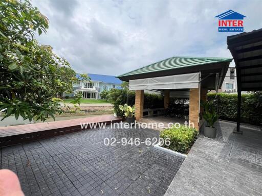 Modern outdoor seating area with covered pavilion and greenery