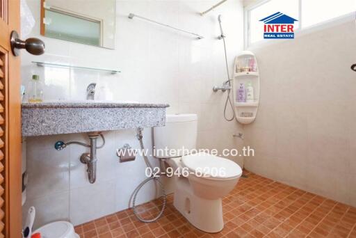 Bathroom with a large mirror, sink, toilet, and shower area