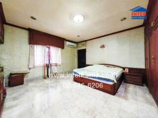Spacious bedroom with marble flooring and built-in wooden wardrobes