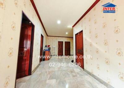 Spacious and well-lit hallway with decorative walls and multiple doorways