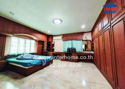 Spacious bedroom with wooden furnishings and tiled floor