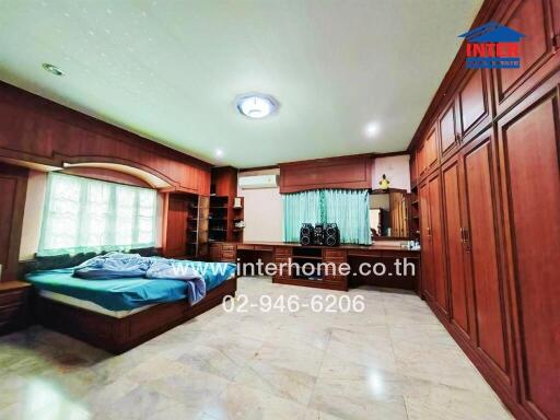 Spacious bedroom with wooden furnishings and tiled floor