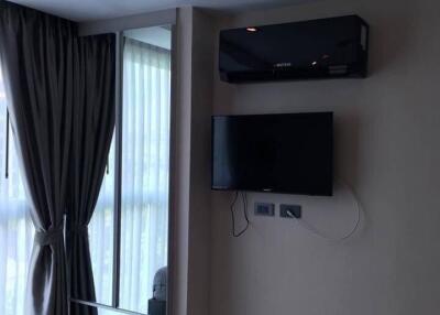 Bedroom with mounted TV and air conditioning unit