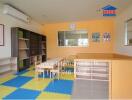 Bright and colorful children's playroom with air conditioning and large storage shelves.