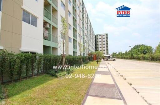 Exterior view of a residential apartment building with parking area