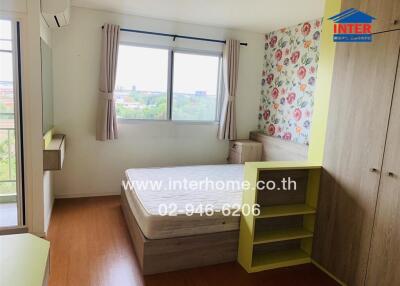 Bedroom with large window and floral accent wall