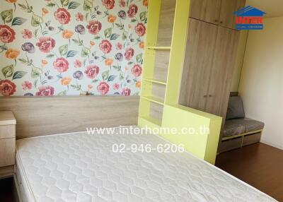 Bedroom with floral wallpaper, wooden furniture, and light-colored mattress