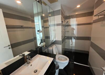 Modern bathroom with sink, toilet, and shower area