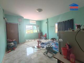 Bedroom with light blue walls, window, bed, and various items