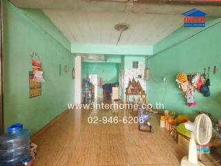 Open living area with wooden flooring and bright green walls