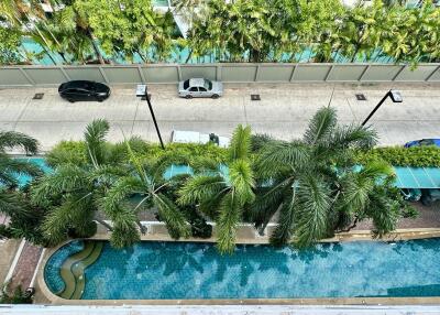 View from the balcony showing a swimming pool and palm trees