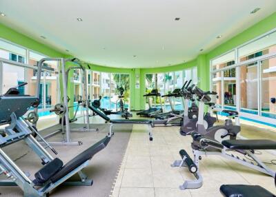 Apartment complex gym with various exercise equipment and pool view