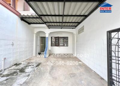Covered outdoor area with metal roof and white walls