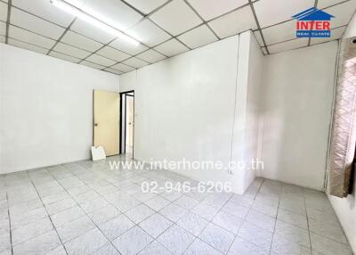 Unfurnished room with tiled floors and window with curtain