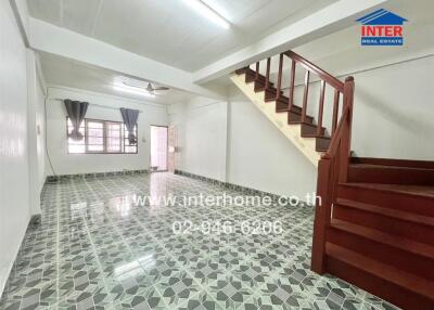Spacious living area with tiled flooring and staircase