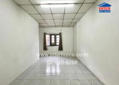Empty room with tiled floor and a window with curtains