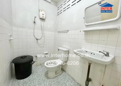 Small bathroom with a toilet, sink, shower, and water heater